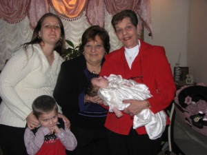 Aunt Millie (in red), my mom, my two kids, and me on the day of Little Miss's christening.